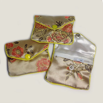 The fronts of three unique gold Floral Crystal Pouch