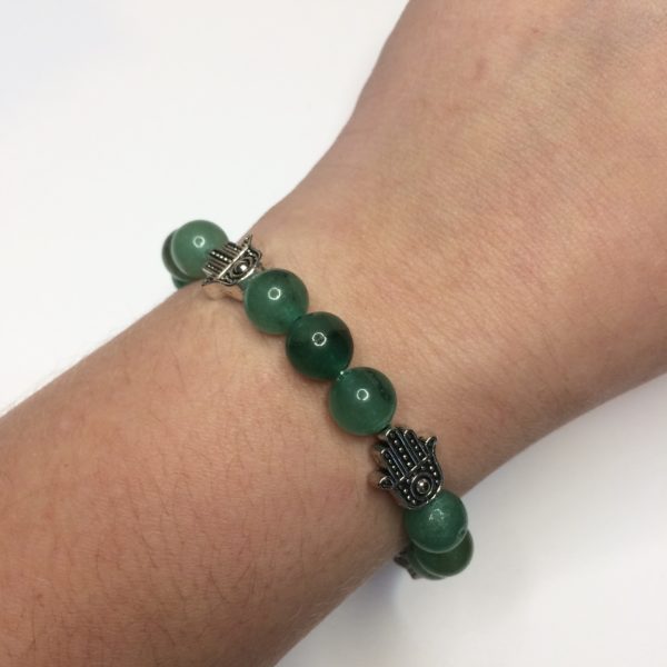 A green Aventurine gemstone bead bracelet with five silver Hand of Fatima beads being worn on a woman's wrist