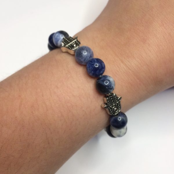 A blue sodalite gemstone bead bracelets with five silver Hand of Fatima beads being worn on a woman's wrist